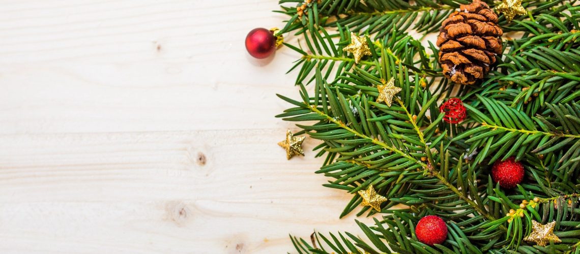 Holztisch mit Zweigen, einem Tannenzapfen und Weihnachts-Deko